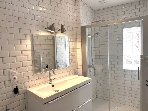 Badkamer met witte metrotegels, wastafel en inloopdouche