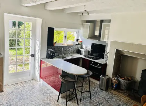 De keuken met bar, gasfornuis en de oude schouw, gezien vanaf de trap
