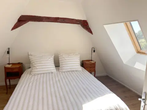Slaapkamer boven met een nieuw tweepersoonsbed onder de schuine balken